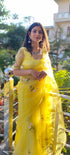 Model wearing a yellow sunflower saree with floral embroidery and elegant accessories