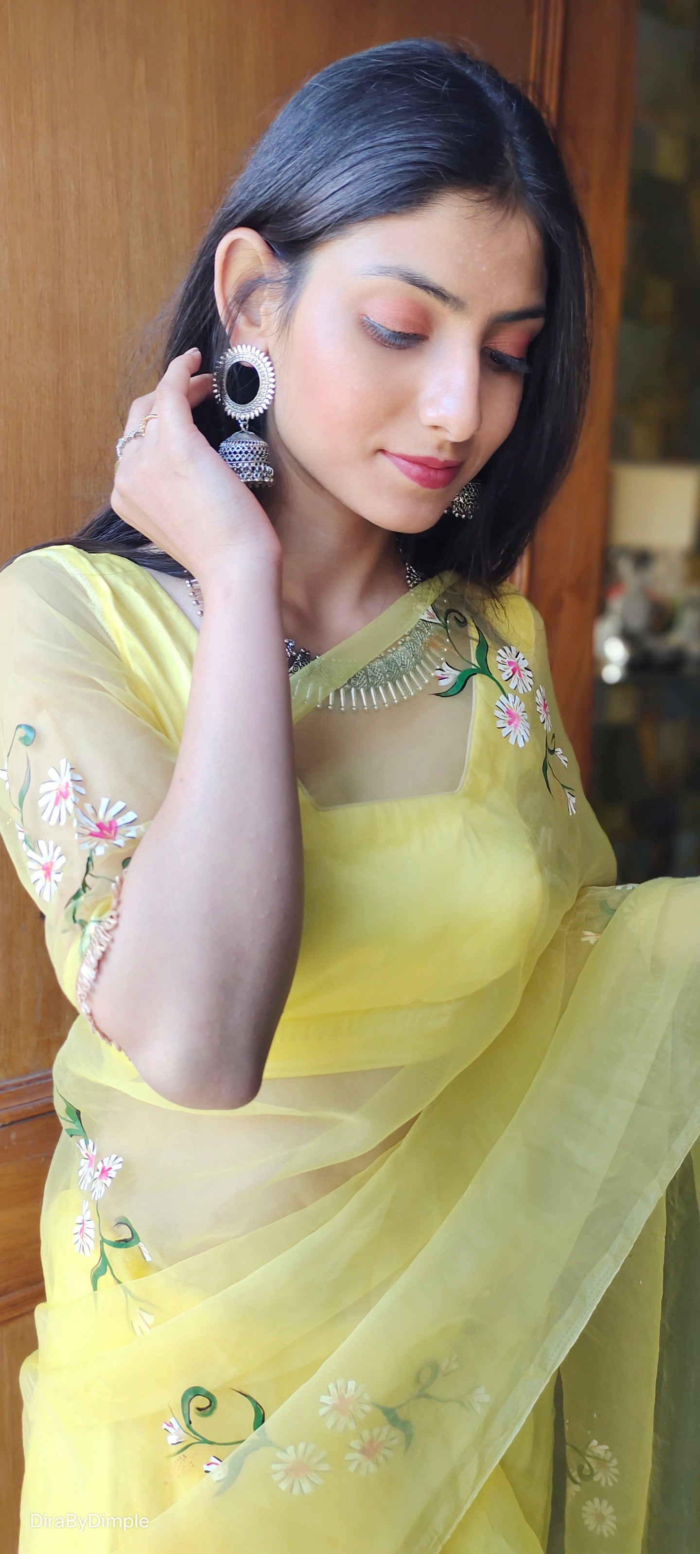 Elegant yellow sunflower saree with floral embroidery, styled with traditional accessories