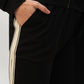 A person with their hand in the pocket of black pants with a white side stripe, styled as part of the Black Co-Ord Set made from soft cotton lycra.