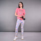 Woman in an 'Adore Your Core' printed tee and colorful leggings holds a water bottle, standing against a gray background.