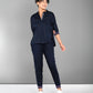 Woman wearing the Accented Set—a navy cotton co-ord featuring a button-up shirt and matching pants—smiling against a plain gray background.