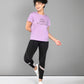 Woman in activewear smiling, wearing a Pilates Pink T-shirt, black leggings, and white sneakers.
