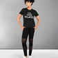 Person wearing a Pilates Black T-shirt and leggings stands with hands on hips against a plain background.