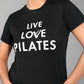 A person wears the Pilates Black T-shirt, a women's cotton modal tee with "LIVE LOVE PILATES" in bold white letters—ideal for any pilates enthusiast.