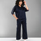 Person with curly hair wearing the Navy Blue Chic Set and white sneakers, standing and smiling.