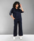 Person with curly hair wearing the Navy Blue Chic Set and white sneakers, standing and smiling.