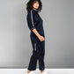 A woman models the Navy Blue Chic Set with white sneakers, posed sideways against a grey backdrop.