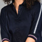 Woman wearing the Navy Blue Chic Set, featuring a navy blue top with batwing sleeves and striped details, shown from shoulders to waist.