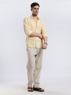 Close-up of a light yellow textured button-down shirt showcasing the breathable linen fabric weave.