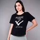 A woman wearing the 'Adore Your Core' Printed Tee and gray leggings poses against a plain backdrop, highlighting this motivational workout shirt ideal for Pilates lovers.