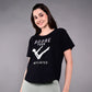 Smiling woman in light leggings, wearing our 'Adore Your Core' Printed Tee against a grey backdrop. This women's cotton modal shirt brings comfort and style—ideal for any Pilates fan.