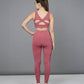 A woman stands with her back to the camera, wearing a Peony Pink Netted Top featuring a HoneyComb Self Pattern and matching leggings.