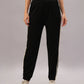 A person models the Black Co-Ord Set made from soft cotton lycra, featuring black track pants with white side stripes, paired with white sneakers against a plain background.
