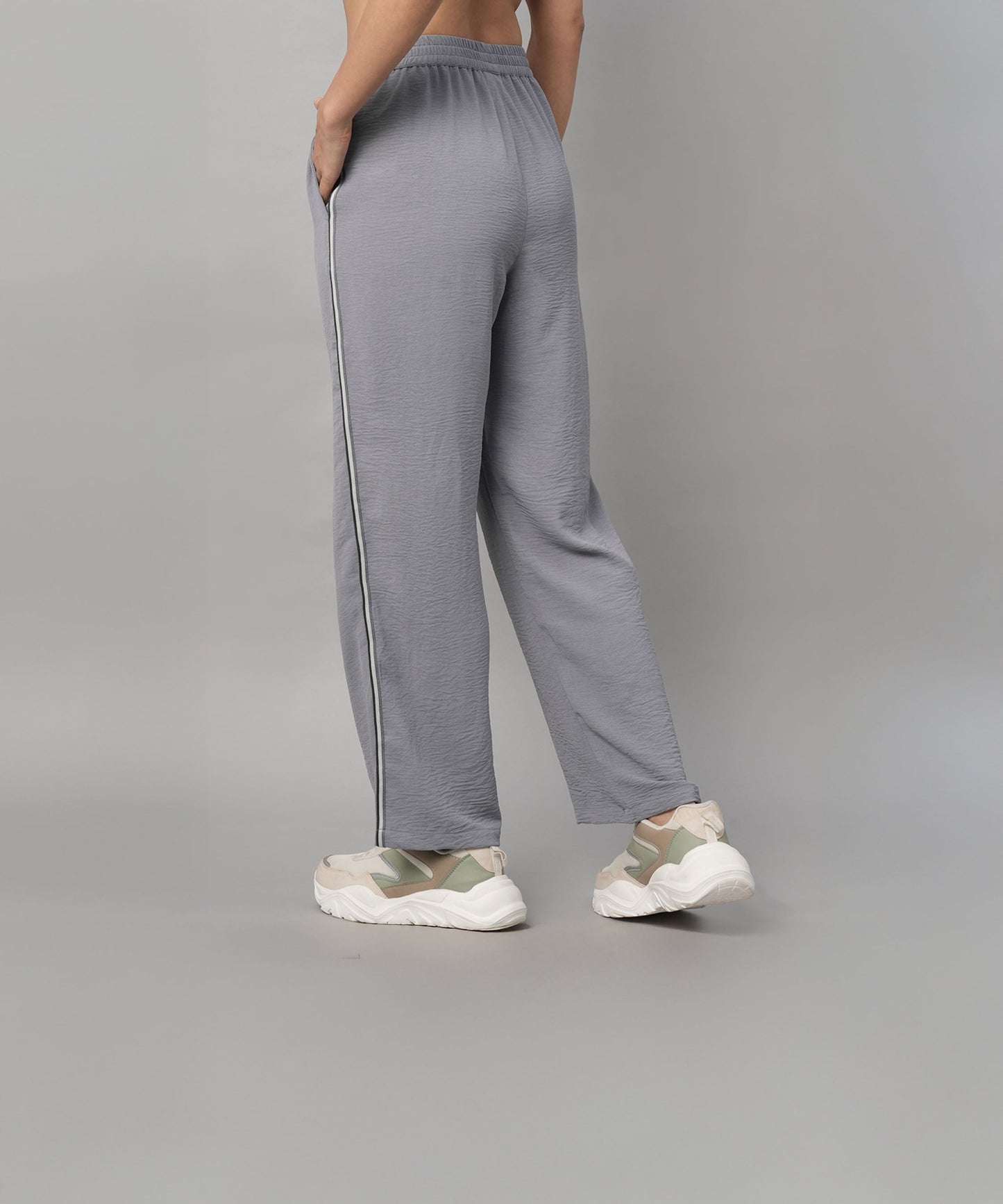Person wearing the Grey Tie Up Top with Loose Pants Cord Set, featuring loose gray pants with a white side stripe and white sneakers, shown from the back.