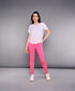 A woman stands against a gray background wearing the &