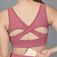 A woman wearing the Peony Pink Netted Top with a cutout back is placing a cardholder into her waistband pocket.