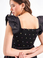Female model wearing a multicolour embroidered black romper from Stylera