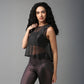 Woman with long curly hair poses confidently in a Black Sheer Top and shiny black leggings.
