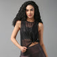 Woman with long curly hair poses in a Black Sheer Top and shiny leggings against a gray background.