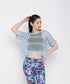 A woman models the Blue Netted Top layered over a black sports bra and vibrant floral leggings, posing against a plain background for a chic, sporty vibe.