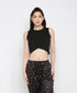 A woman wears the Black Twisted Crop Top with black printed pants, standing against a white background.