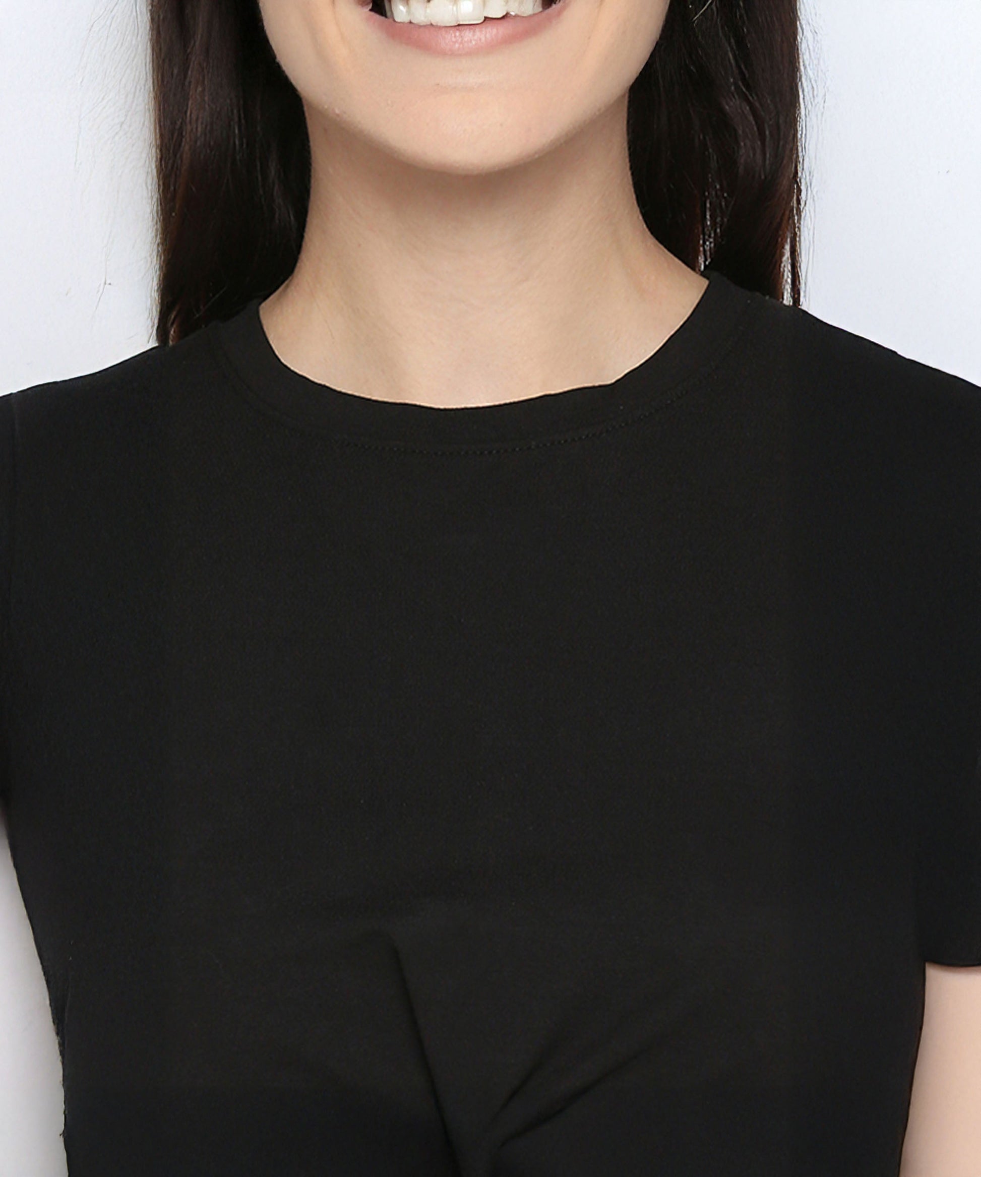 A smiling person, shown from shoulders to chin, wears the Black Twisted Crop Top.