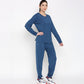A woman models the Atlantic Blue Active Duo—cotton modal joggers paired with a blue racerback top—and white sneakers, standing against a plain white background.