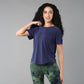 Woman with long curly hair wears the Functional - Blue Soft T Shirt, made from durable, comfortable materials, posing against a gray background.