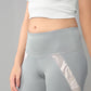 Woman in a Grey Top with Patched Legging, featuring moisture-wicking fabric to keep you cool while showing off your midriff.