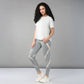 Woman with long curly hair wears the Grey Top with Patched Legging, made from super soft, moisture-wicking fabric, paired with sneakers and poses against a plain gray background.