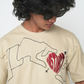 Stylera trendy neutral color t-shirt beige with black line art hands and red heart graphic on model