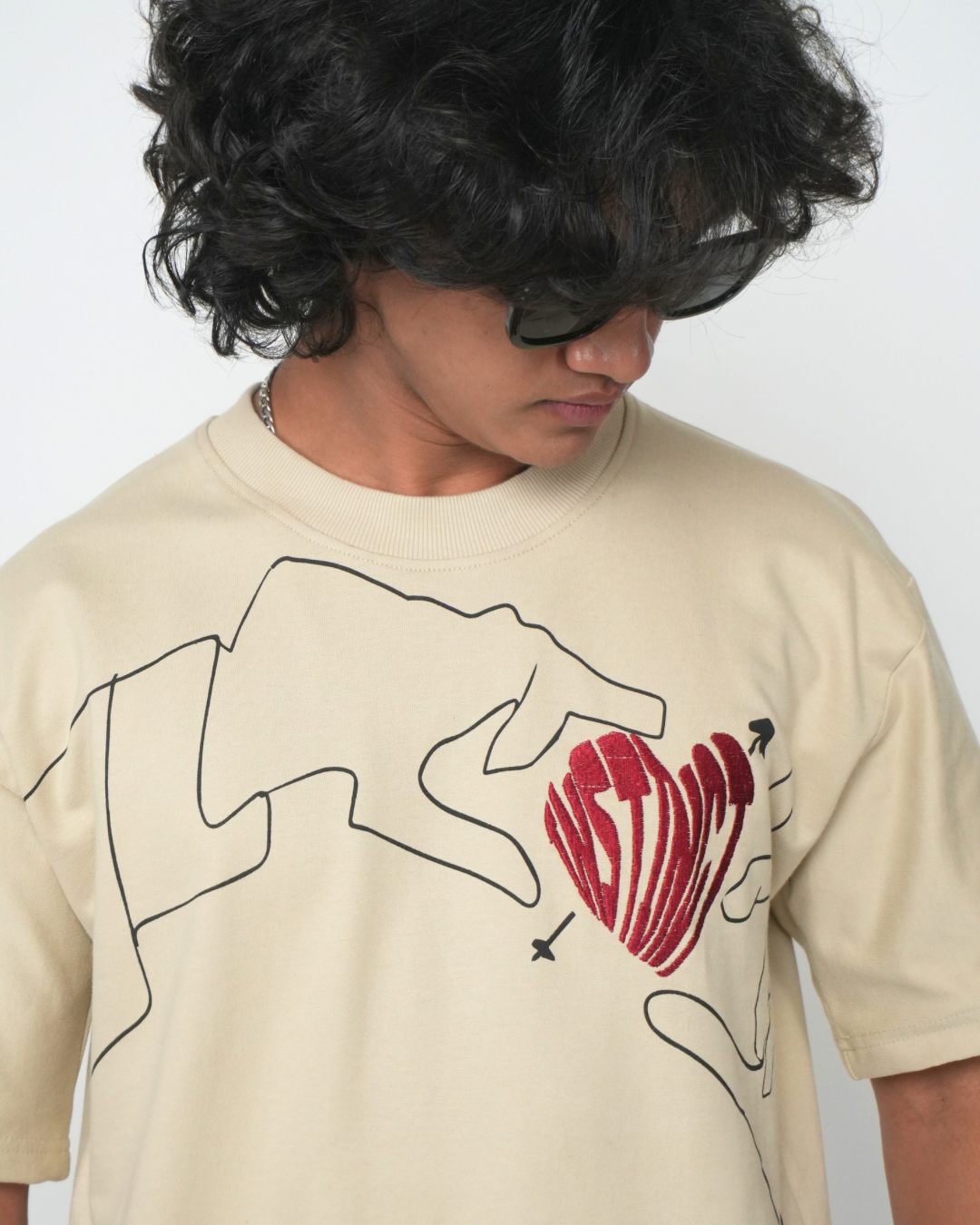 Stylera trendy neutral color t-shirt beige with black line art hands and red heart graphic on model
