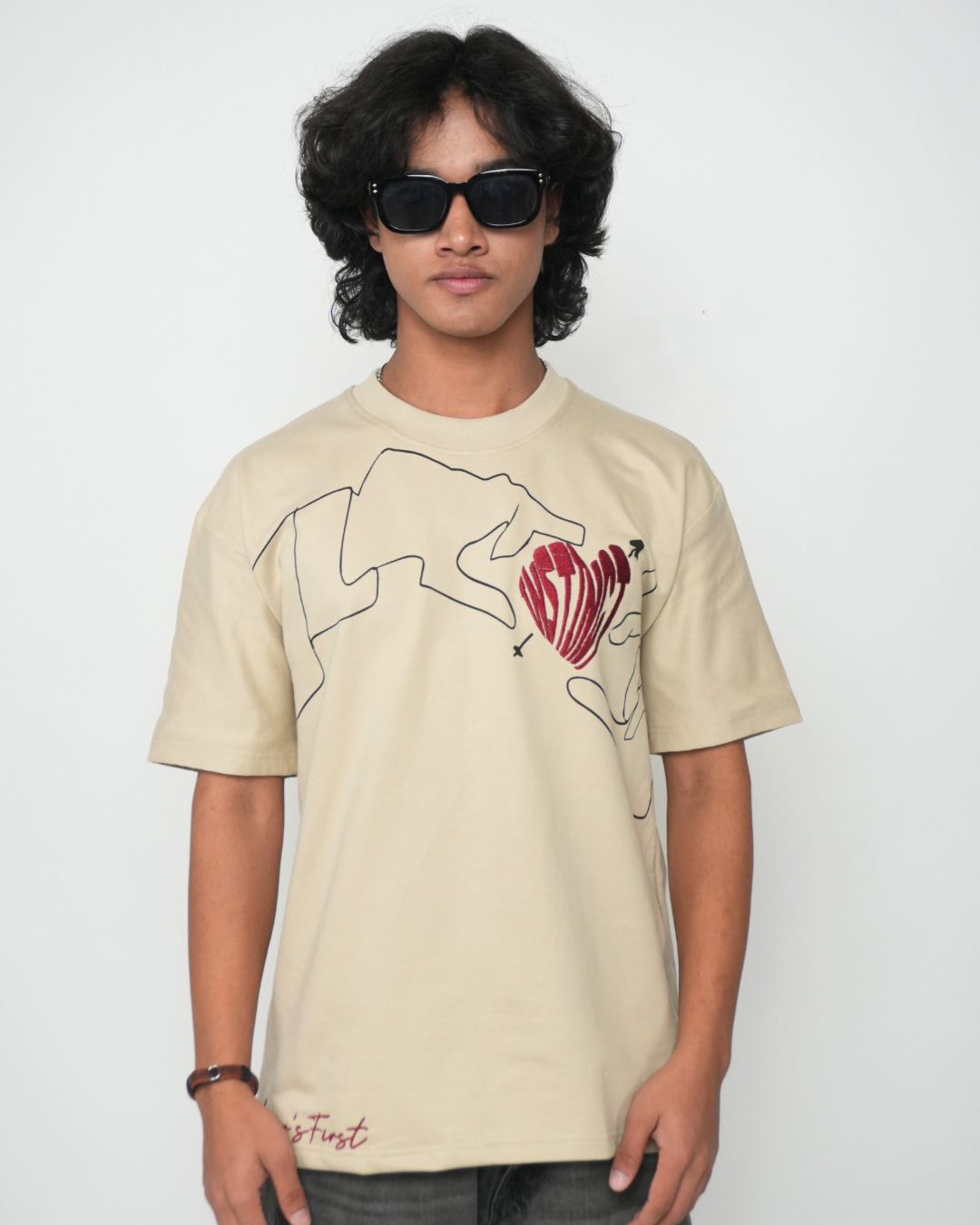 Stylera beige T shirt with abstract hand line art and red heart worn by model in sunglasses trendy neutral color t-shirt