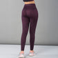 Model faces away from the camera, wearing Pink Animal Print Leggings and sneakers against a plain gray background.