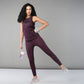 Woman wearing pink animal print leggings poses on one leg with a water bottle and sneakers.