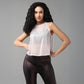 Woman with long curly hair poses confidently in a Powder Pink Sheer Top and black leggings.