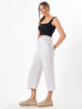 Female model wearing a white pants from Stylera, styling with black top