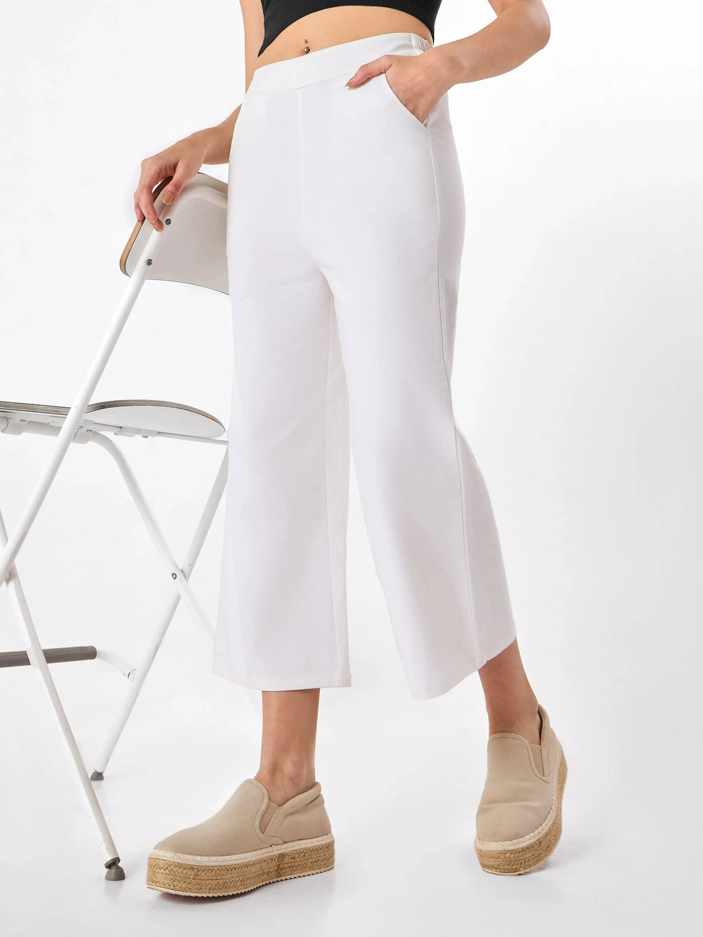 Female model wearing a white pants with slip pockets from Stylera, styling with black top