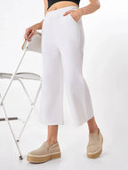 Female model wearing a white pants with slip pockets from Stylera, styling with black top