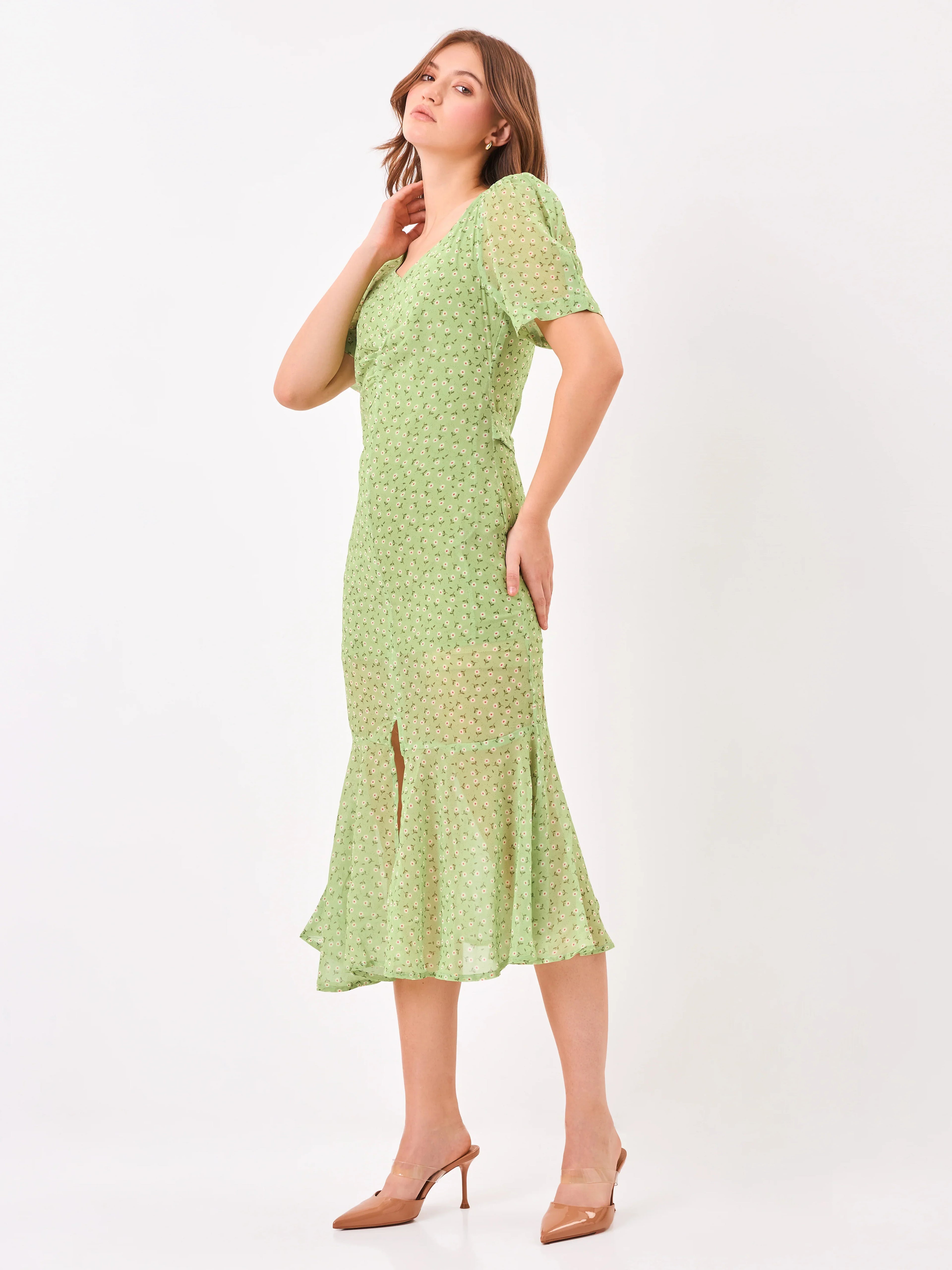 Female model wearing a green dress with a slit from Stylera, showcasing side angle