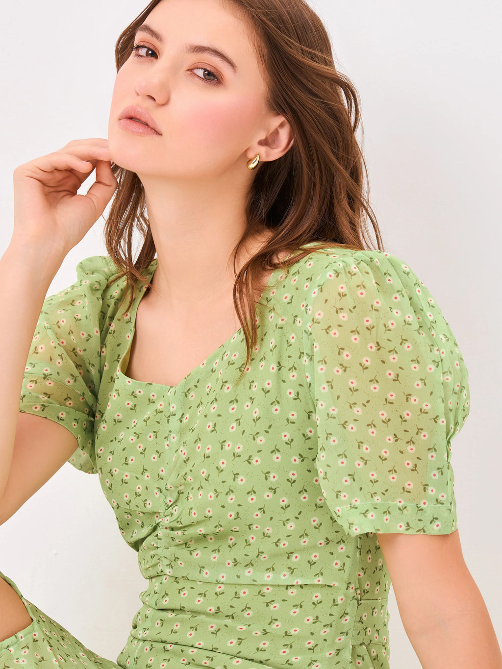 Female model wearing a puff sleeve green dress with a slit from Stylera