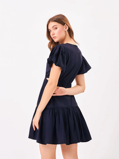 Female model wearing a navy blue dress from Stylera, showcasing backside