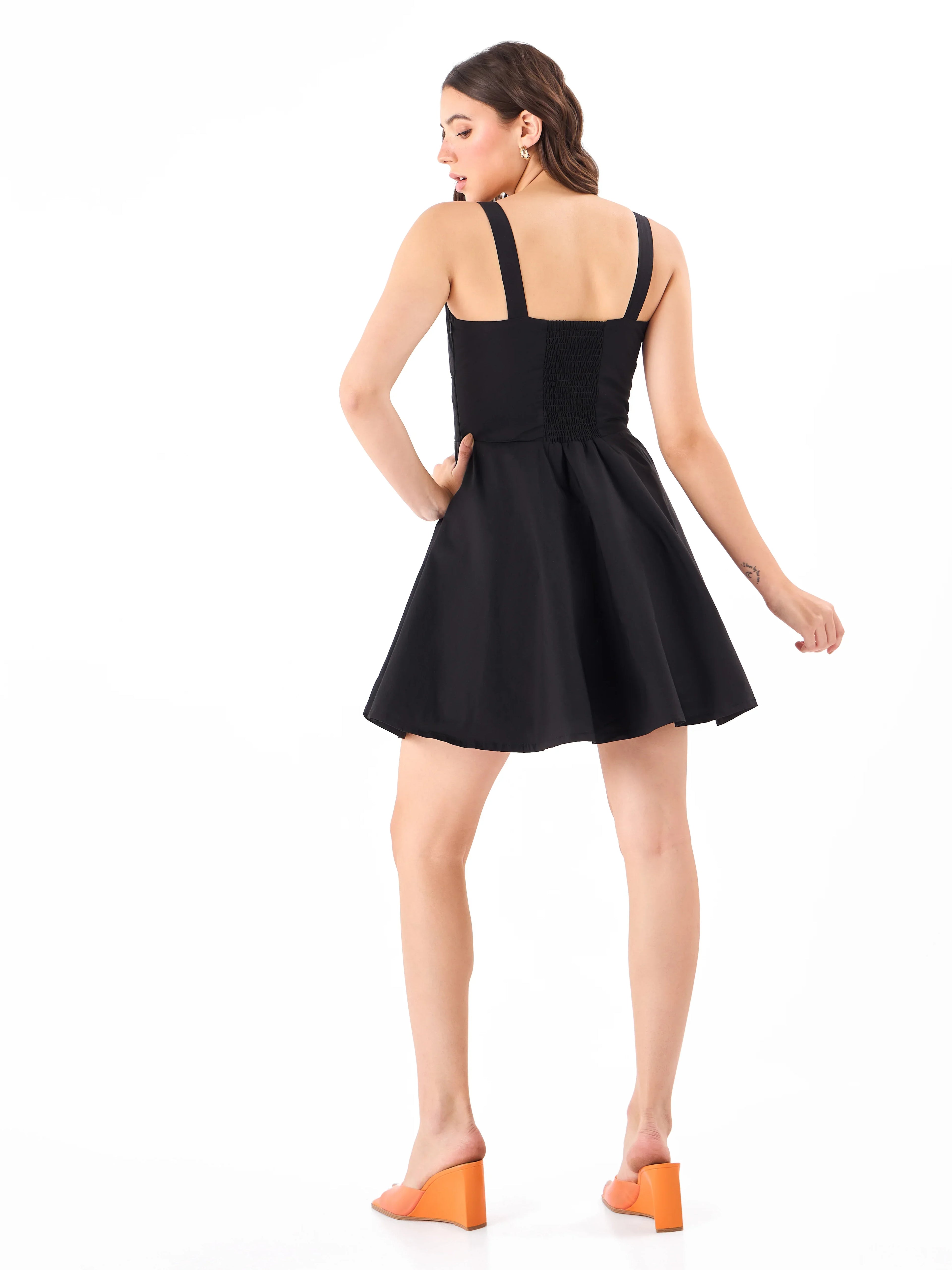 Female model wearing a casual black sleeveless dress from Stylera, showcasing backside