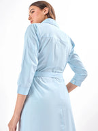 Female model wearing a light blue and orange dress with a belt from Stylera