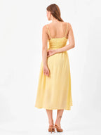 Female model wearing a yellow midi dress from Stylera, showcasing backside