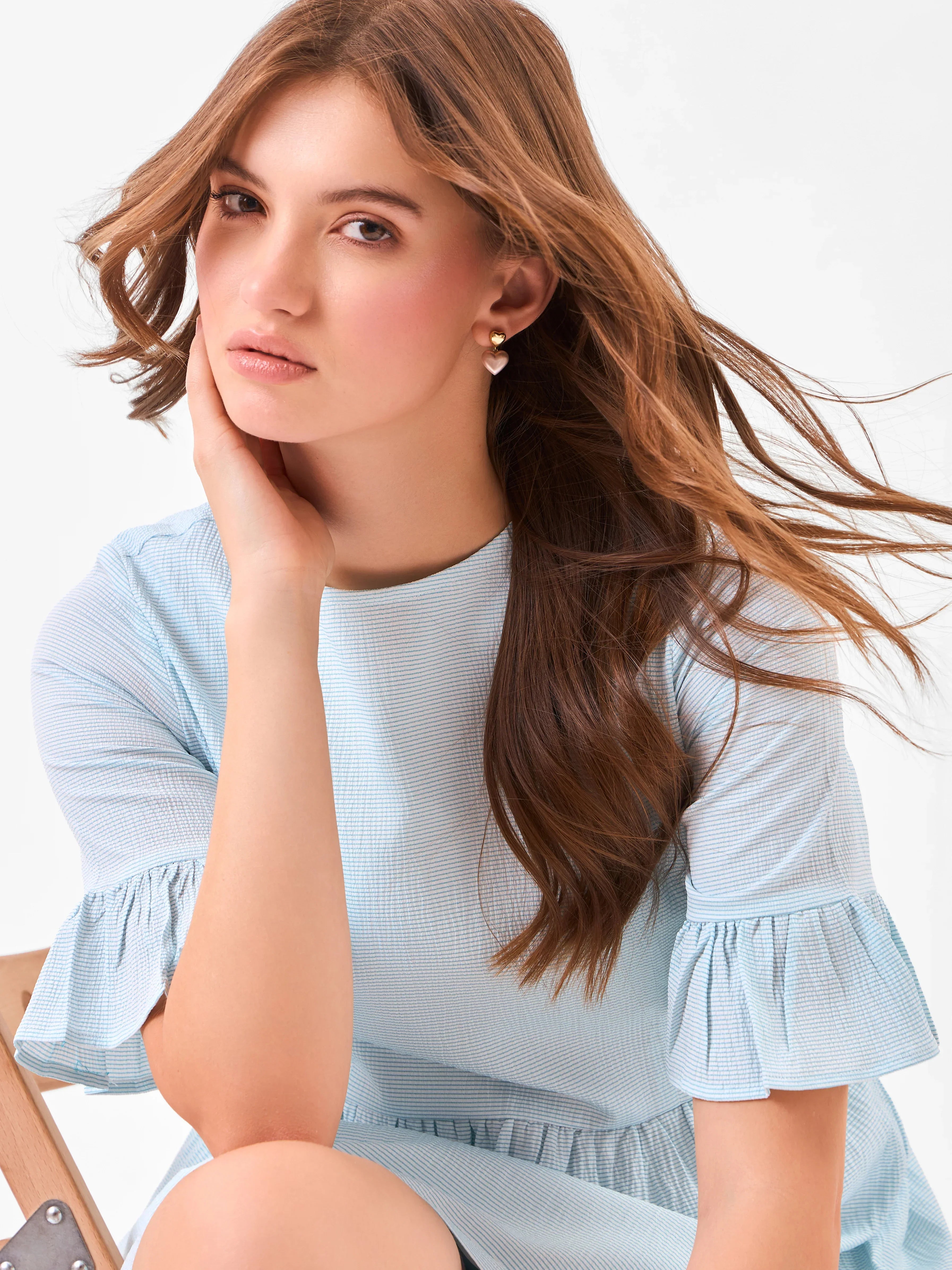 Female model wearing a round neck light blue dress from Stylera