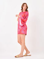 Female model wearing a one side 3/4 sleeve pink tie-dye dress from Stylera