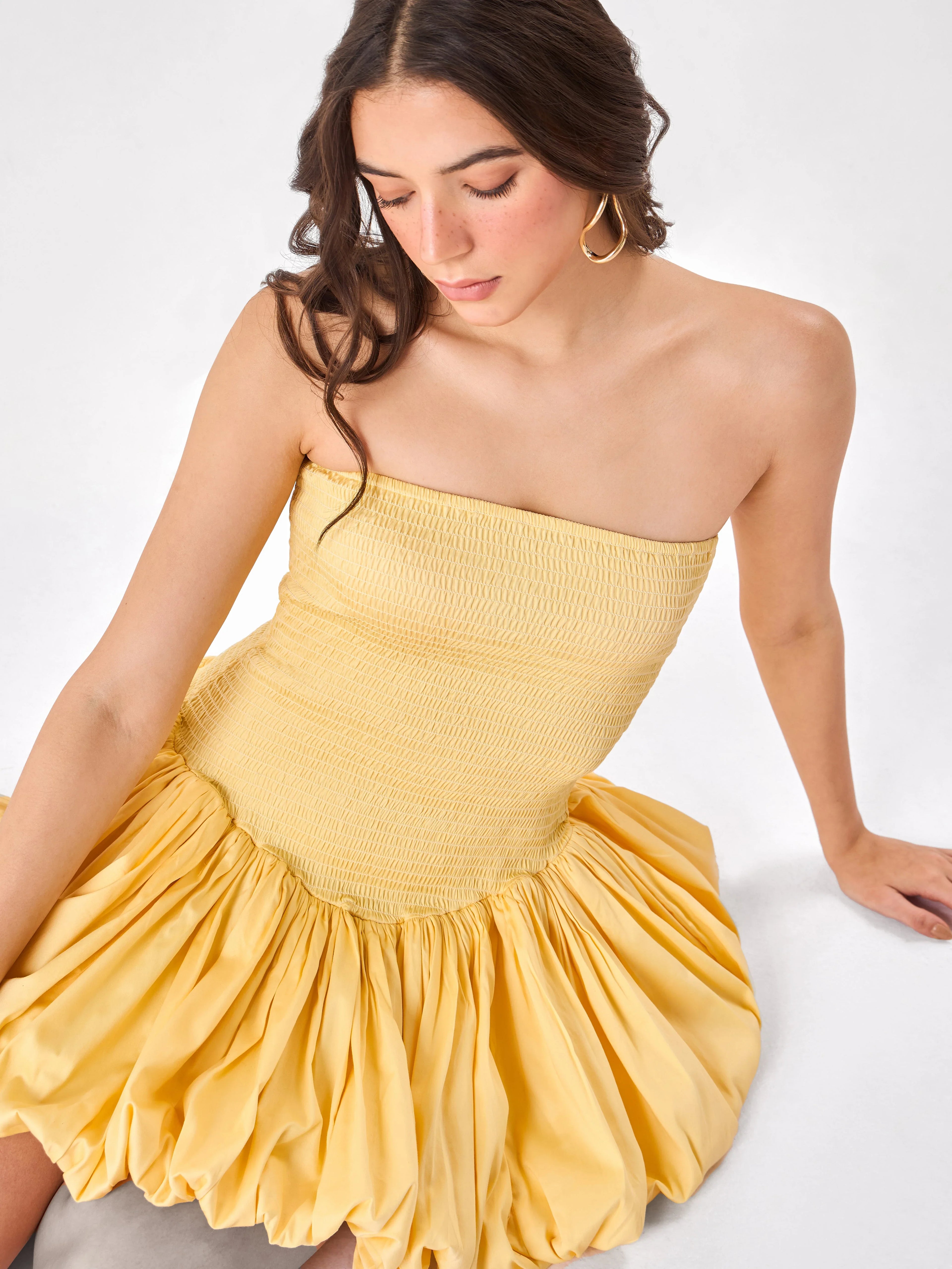 Female model wearing a yellow strapless frill dress from Stylera