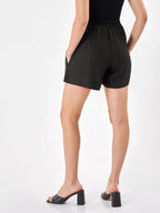 Female model wearing a black shorts from Stylera, showcasing backside