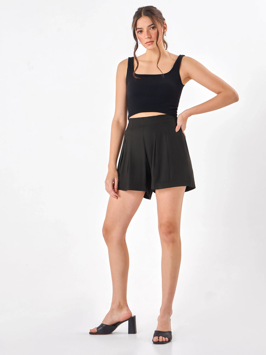 Female model wearing a black shorts from Stylera, styling with black tank top